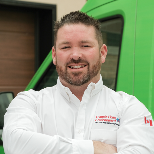 Francis technician standing by our famous green trucks in a residential neighbourhood.