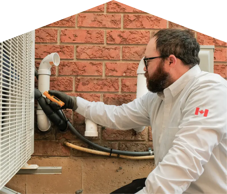 Heat-Pump-Detection-banner-webp Francis HVAC specialist checking insulated piping on a heat pump unit beside a brick wall during a diagnostic service.