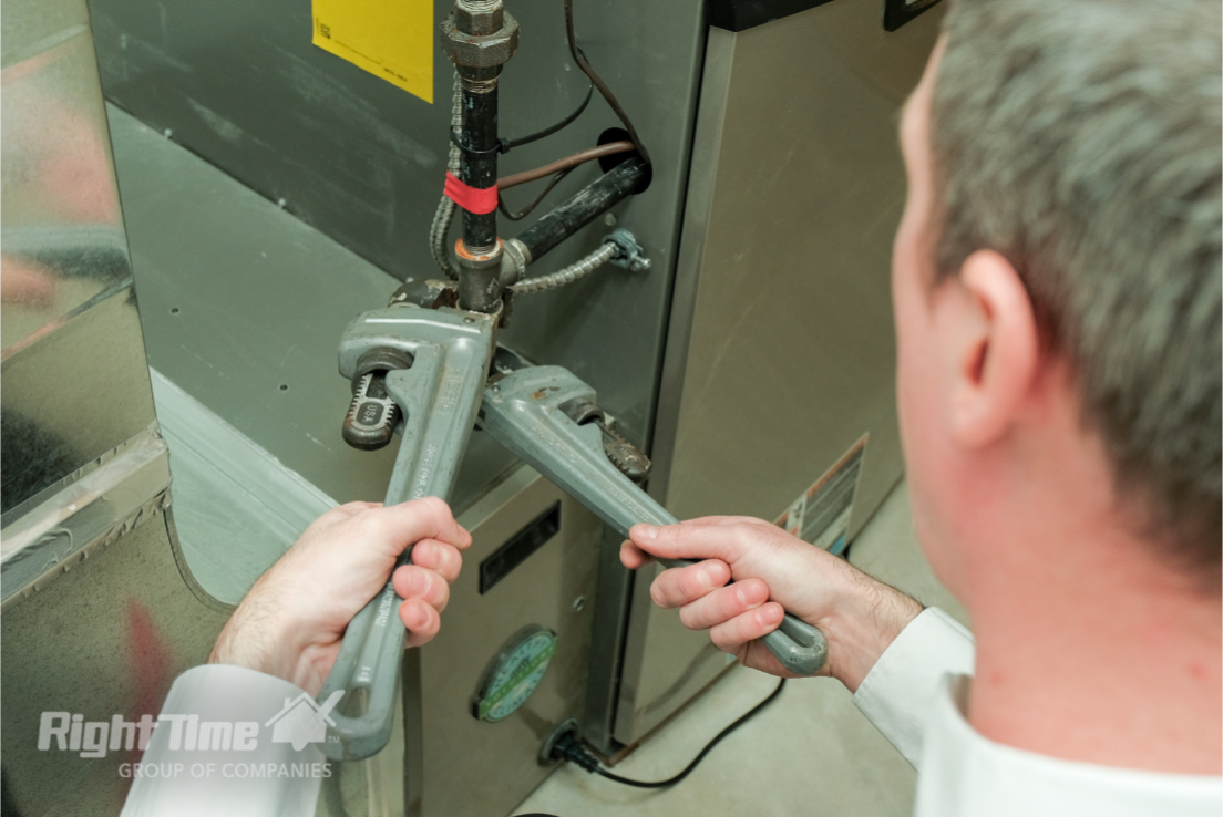 HVAC technician using wrenches to adjust furnace plumbing connections during maintenance service in Ottawa, addressing issues with furnace running too long